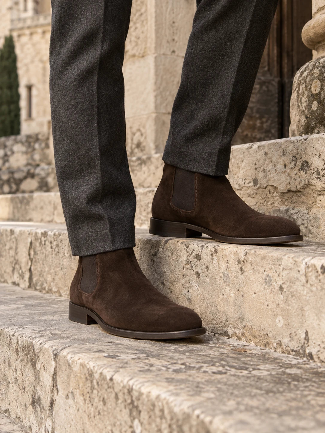 Chocolate suede Chelsea boots with charcoal trousers on stone steps